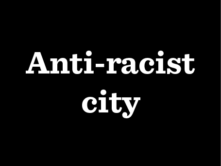 A black square with white text reading Anti-racist city.